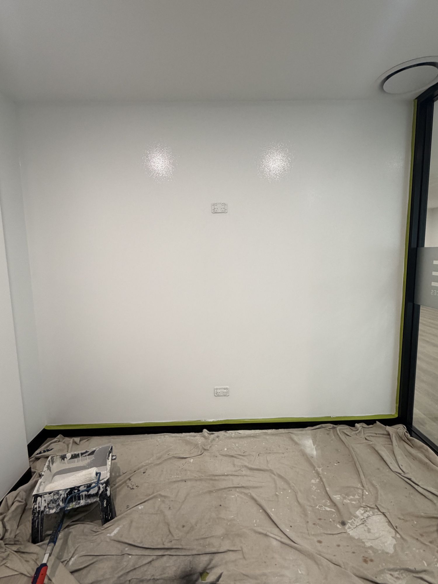 Freshly painted open-plan office space with white walls and dark carpet