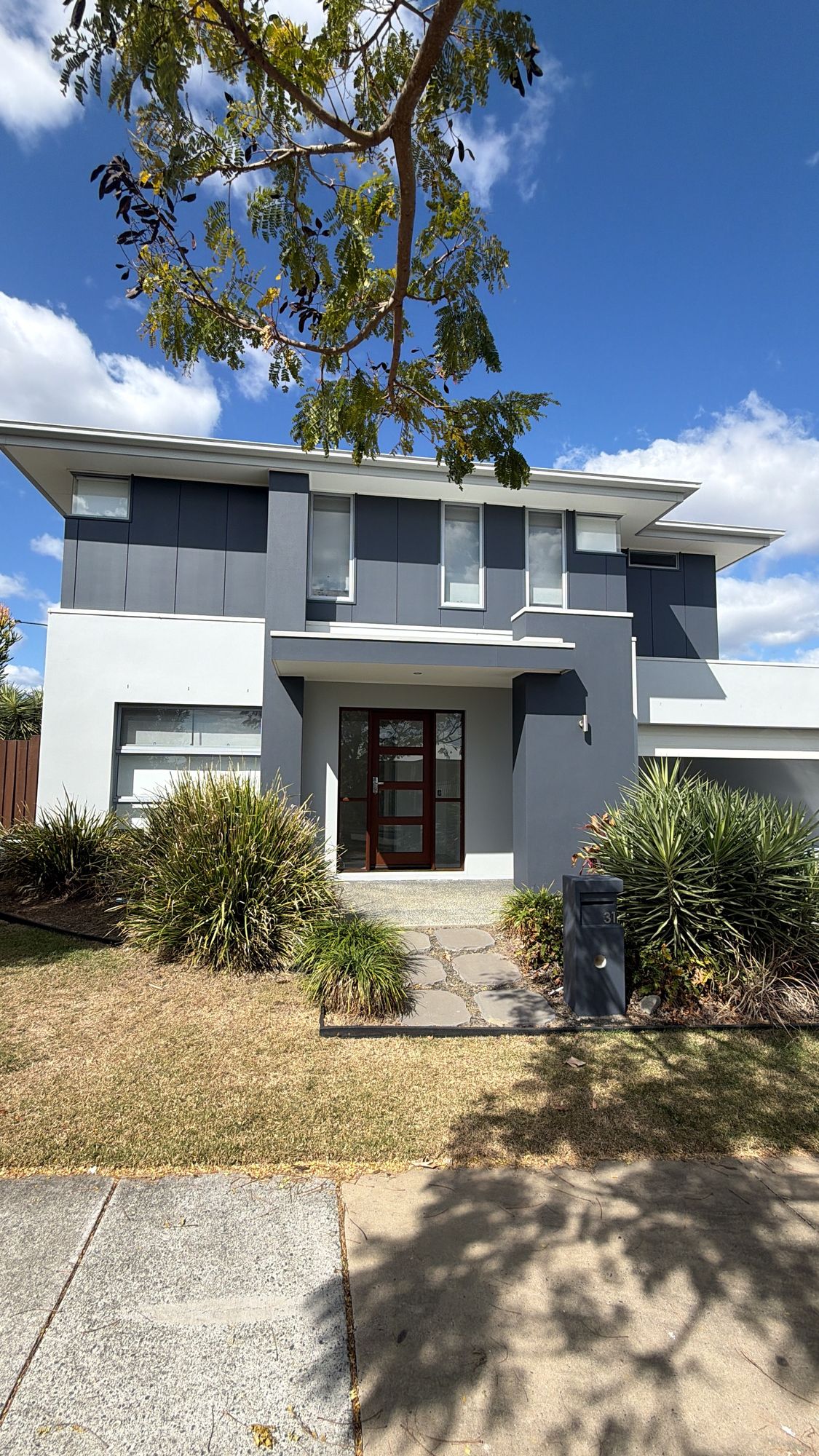 Two-storey home exterior painted in charcoal and white